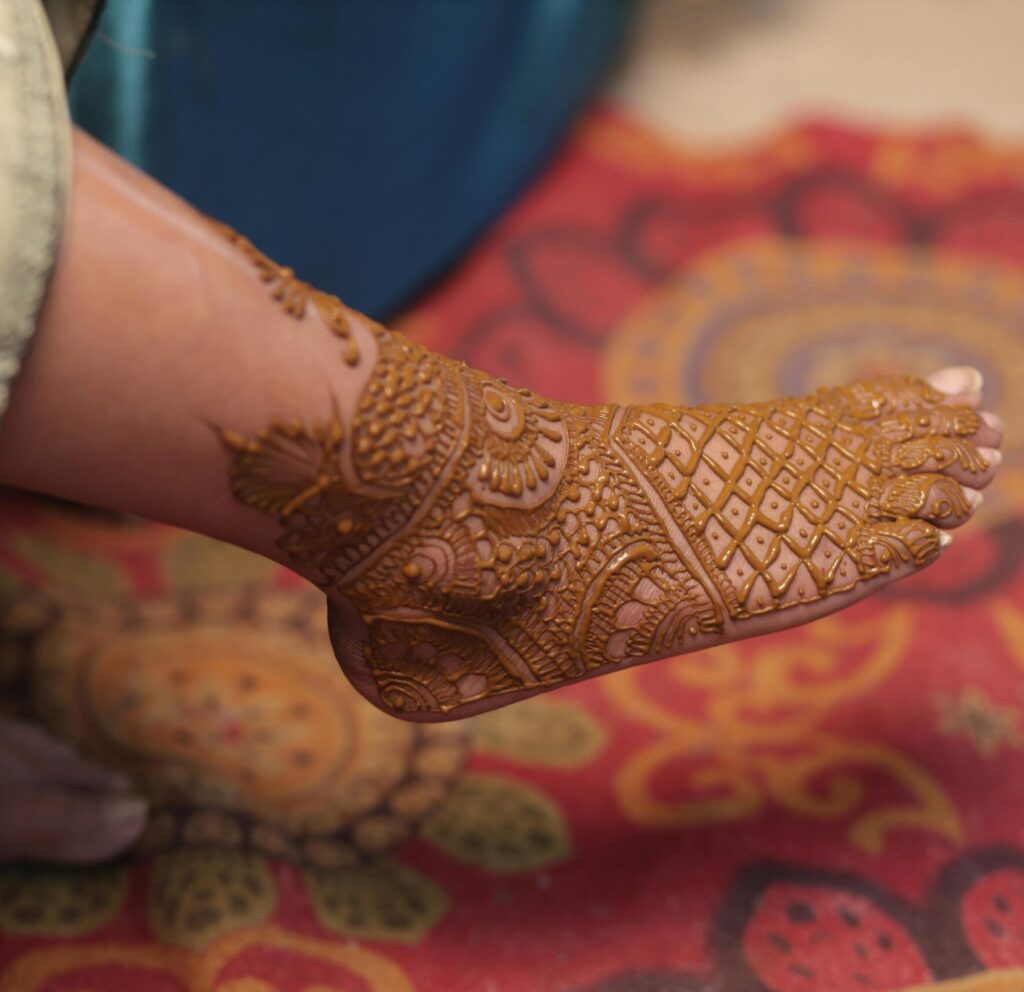 Close-up of traditional henna patterns adorning a bride's foot for an Indian wedding ceremony.